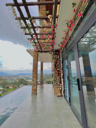 a balcony with flowers on the side of a building at Hồ Bơi Vô Cực - Có Thể Săn Mây Tại Giường in Da Thanh