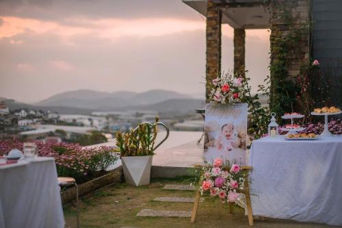 a group of tables with flowers and food on them at Hồ Bơi Vô Cực - Có Thể Săn Mây Tại Giường in Da Thanh