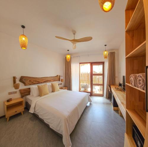 a bedroom with a large bed with a ceiling fan at Muraka Dhigurah in Dhigurah