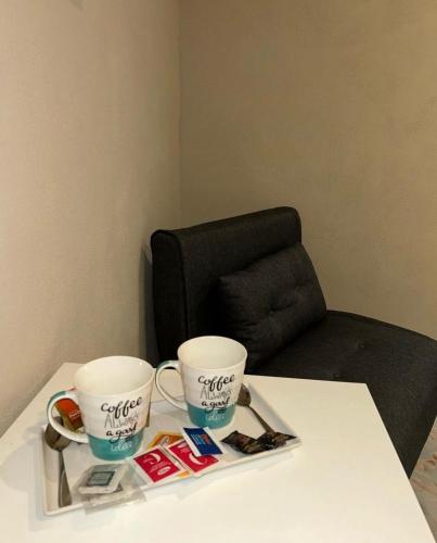 two coffee cups on a table with a chair at Business House in Naples