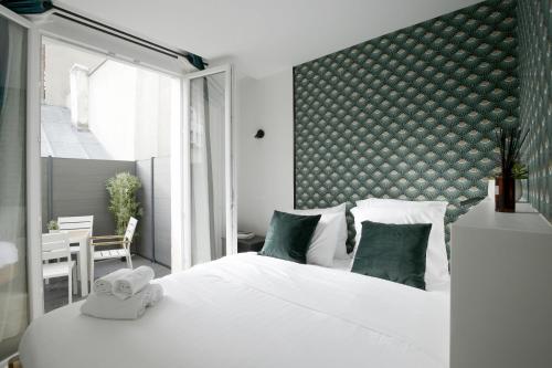 - une chambre avec un grand lit blanc et une tête de lit verte dans l'établissement Chill-out on Private Patio in Vintage Masterpiece, à Paris
