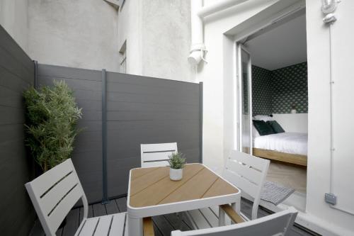 Elle comprend un petit balcon avec une table et des chaises en bois. dans l'établissement Chill-out on Private Patio in Vintage Masterpiece, à Paris