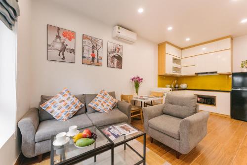 un salon avec un canapé et deux chaises dans l'établissement Oikia Westlake Apartment, à Hanoï