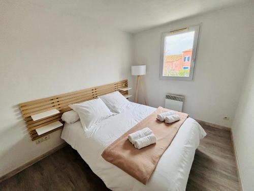 une chambre avec un grand lit blanc avec une fenêtre dans l'établissement Maison de vacances avec piscines, à Béziers