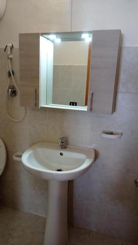 a bathroom with a white sink and a mirror at Residence Punta Cilento in Pisciotta