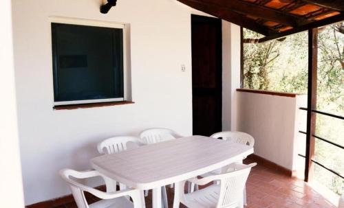 a white table and chairs in a room with a tv at Residence Punta Cilento in Pisciotta
