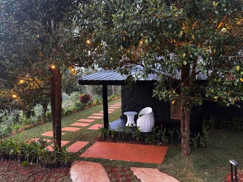 a small shed with two toilets in a garden at Viceroy Luxury Mountain Resort and Spa in Munnar