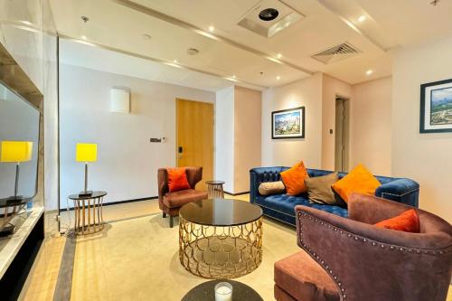 a living room with a blue couch and orange pillows at Fairfield by Marriott Chow Kit Kuala Lumpur in Kuala Lumpur