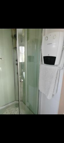 d'une douche avec une porte en verre et une serviette. dans l'établissement Villa Elephantine, à Bormes-les-Mimosas