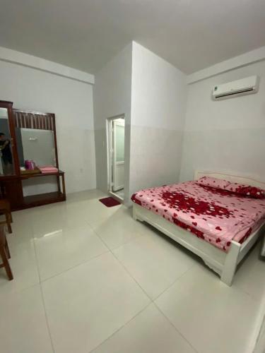 a white bedroom with a bed and a mirror at Sao Biển Motel Phú Quốc in Phu Quoc