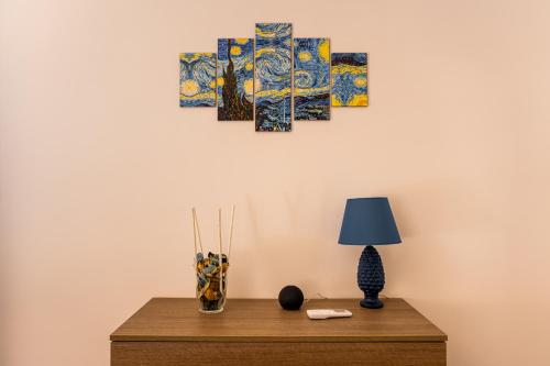 a table with a lamp and paintings on a wall at Torre dei Venti in Ceccano