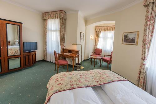 a hotel room with a bed, table and chairs at Hotel Kaiserhof Eisenach in Eisenach