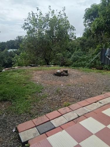 a backyard with a fire pit in the grass at Roamwander Apartments in Vagamon