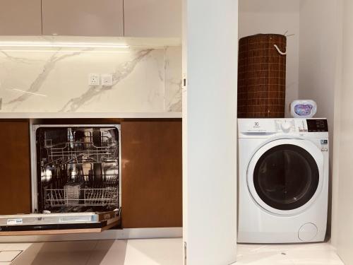 a kitchen with a microwave and a washing machine at 2BR Soul Beach Mamsha Al Saadiyat Full Apartment in Abu Dhabi