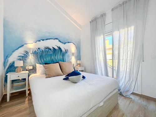 a bedroom with a large white bed with a blue headboard at La Vela Estartit Rental in L'Estartit