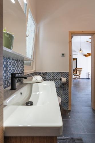 a bathroom with a white sink and a room at Summer cottage 1 in Novalja