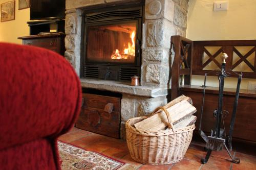 a living room with a fireplace and a red couch at Casa Vacanze Le Antiche Pietre in Ortignano Raggiolo