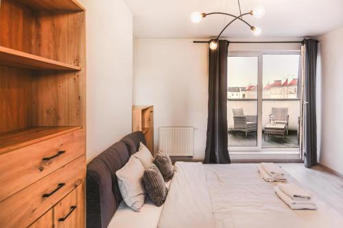 a bedroom with a large bed and a window at Komfortowe apartamenty w centrum Wrocławia in Wrocław