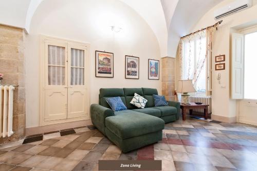 a living room with a green couch and a window at Corte del Fanfulla - Lecce Selection in Lecce