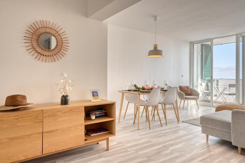 a living room with a table and chairs and a mirror at Maranta House, a Home in Madeira in Funchal