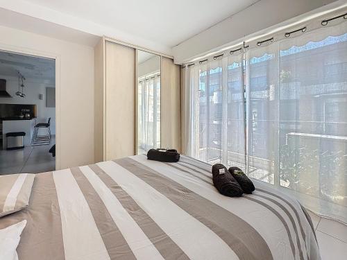 une chambre avec un grand lit avec une grande fenêtre dans l'établissement 57m2 - 2 chambres, terrasse, Croisette-Martinez, à Cannes