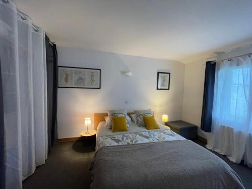 une chambre avec un lit avec des oreillers jaunes et une fenêtre dans l'établissement Joli appartement rénové avec jardin clos, à La Tremblade