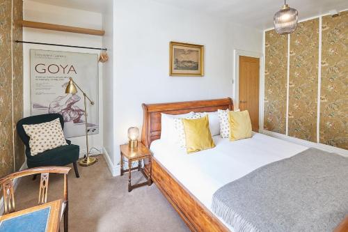 a bedroom with a large bed and a chair at Traditional cottage with brand new Woodburner in Wark