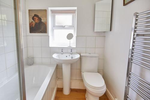 a bathroom with a toilet and a sink and a bath tub at Traditional cottage with brand new Woodburner in Wark