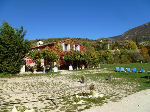 une maison sur une plage avec des chaises en face de celle-ci dans l'établissement Gîte de Vénascle, à Moustiers-Sainte-Marie