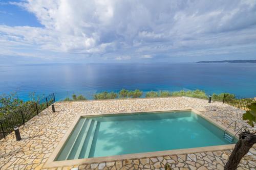 a swimming pool with a view of the water at Skali Retreat in Atsoupádhes