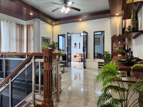 a living room with a ceiling fan and a staircase at Goldland Caelestis Guest House in Bacolod