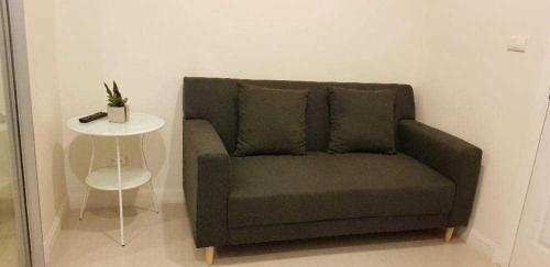 a couch in a room with a side table at Mari Space Riverview in Nonthaburi