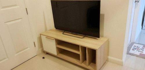 a flat screen tv sitting on top of a wooden stand at Mari's space Riverview in Nonthaburi