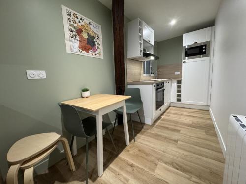 une petite cuisine avec une table et des chaises en bois dans l'établissement Le Grand Victor - 7 pers - Hyper Centre - Rêve au Mans, au Mans