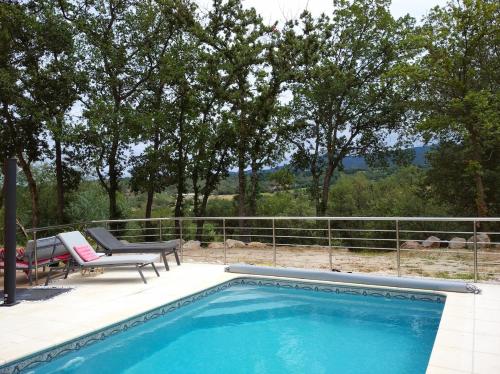 - une piscine avec un banc, une table et des chaises dans l'établissement Villa les hirondelles avec piscine chauffée, à Prades