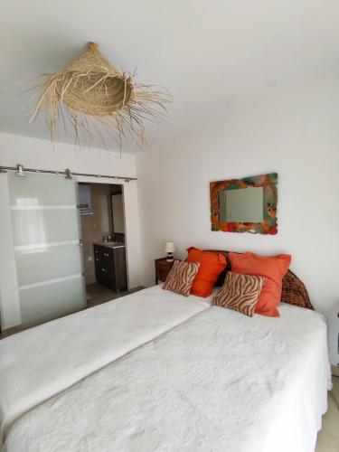 une chambre avec un grand lit blanc avec des oreillers orange dans l'établissement Villa les hirondelles avec piscine chauffée, à Prades