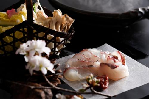 a plate of food with sushi and flowers on a table at Ichiboukan Hanare Kai in Kyotango