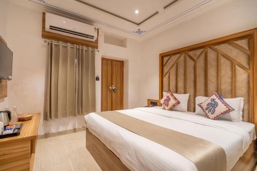 ein Schlafzimmer mit einem großen Bett und einem Fernseher in der Unterkunft Amoraya Udaipur in Udaipur