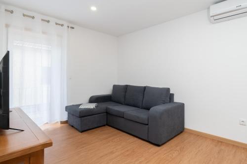 a living room with a couch and a tv at Casa da Petisqueira 54, Paredes-Oporto in Rebordosa