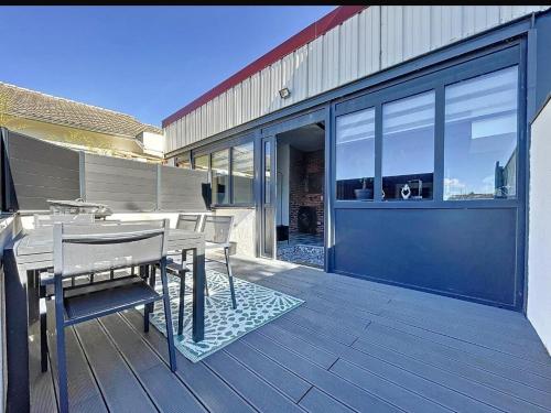 a wooden deck with a table and chairs on a house at Le Loft d 'Éveux - 2 places de parking in Éveux