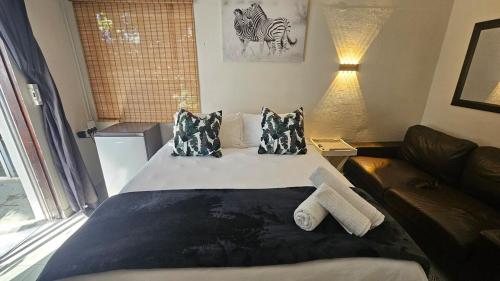 a large bed in a room with a couch at Jacuzzi, Airport, St George's Park in Gqeberha