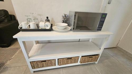 a microwave on top of a white table at Jacuzzi, Airport, St George's Park in Gqeberha