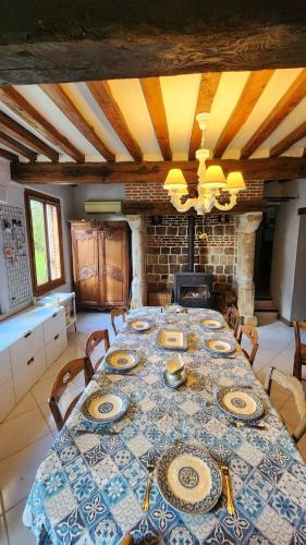 - une salle à manger avec une table et des assiettes dans l'établissement La Parenthèse Normande, à Sainte-Colombe