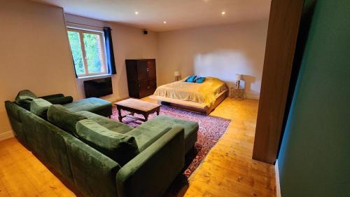 un salon avec un canapé et un lit dans l'établissement La Parenthèse Normande, à Sainte-Colombe