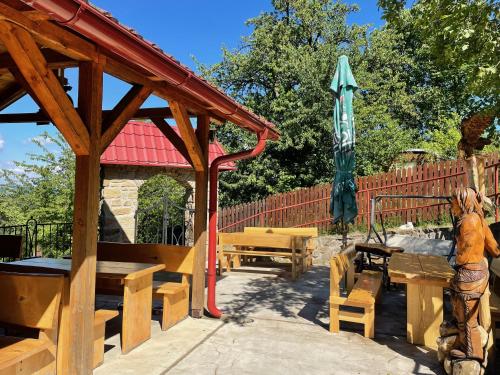 a wooden pavilion with a table and a umbrella at Penzion Pulčínské Skály in Pulčín