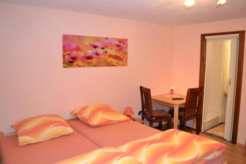 a bedroom with a bed and a table and a painting on the wall at Pension Haus Rohrmoser in Annaberg im Lammertal
