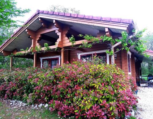a house with flowers in front of it at Chalet au calme cœur du LOT in Mauroux