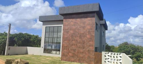 a house with a brick wall next to a white fence at Casa completa Porto Sauipe in Porto de Sauipe