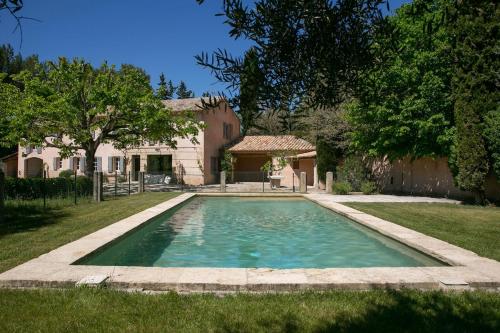 une piscine dans la cour d'une maison dans l'établissement Le mas provençal d'Aurélie, à Carpentras