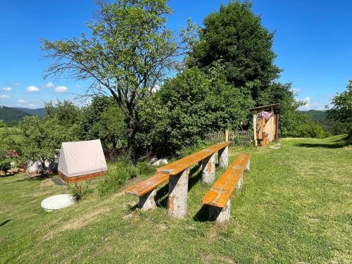 a wooden bench sitting on top of a field at Penzion Pulčínské Skály in Pulčín